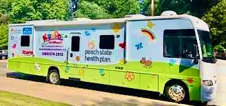 A peach state health plan bus parked on the side of road.