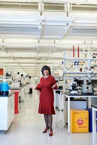 A woman in red dress standing inside of a lab.
