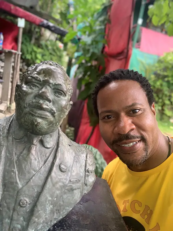A man standing next to a statue of a person.