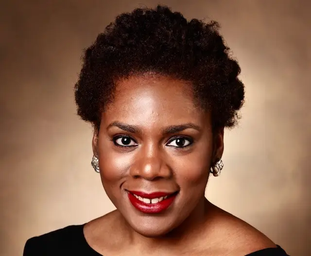 A woman with big hair and red lipstick.