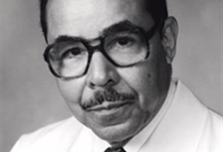 A black and white photo of an older man wearing glasses.