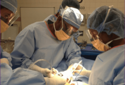 A surgeon and two other surgeons in the operating room.